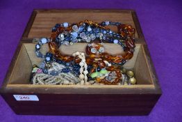 A treen jewellery box having monogram HD to lid, containing a small selection of costume jewellery