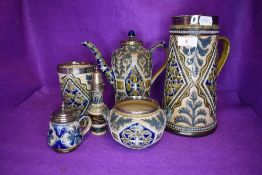 A selection of Doulton Lambeth table wares havine HM silver rims and fitments including water jug