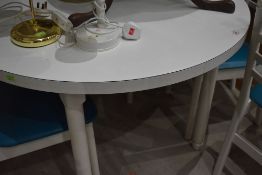 A mid century circular dining table having set of four teal seated ladder back chairs