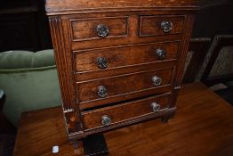 An Edwardian miniature or specimen drawer set having glass handle with beaded and column frontage
