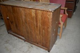 A rustic pine side cabinet having sliding doors