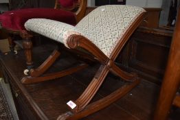 An antique rocking foot or gout stool having fluted frame and upholstered seat