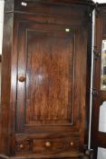 A Victorian corner cupboard having decorated veneer front with integral draw sets