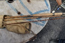 A vintage cane fishing rod approx 11ft unmarked with sleeve