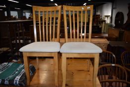 A set of four modern rubberwood dining chairs having upholstered seats