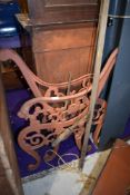 A pair of cast bench ends and a tree lopper