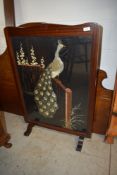 A Victorian mahogany framed ire screen having peacock needle work decoration front