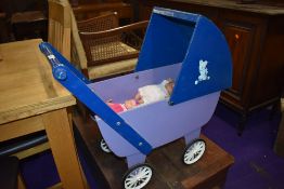 A vintage wooden dolls pram and three rubberoid dolls