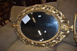 A late 18th century oval shaped mirror having acanthus leaf carved gilt and gesso frame work with