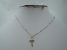 A yellow metal bar brooch stamped 9ct having a central opal and a 9ct gold cross pendant on a yellow