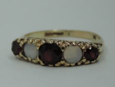 A five stone garnet and opal dress ring having a moulded scroll gallery mount on a 9ct gold loop,