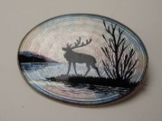 A Norwegian silver brooch having an enamelled guilloche scene depicting a moose