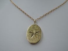 A 9ct gold oval locket having brushed finish with cut star decoration to front, on a 9ct gold