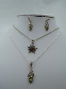 An Edwardian silver pendant in the form of an embossed star having a central red paste gem on a
