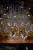 A large assortment of vintage and retro glasses and a decanter, various styles and sizes including