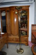 A vintage brass trifold fireguard and a modern reading lamp/uplighter