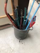 A galvanised water bin with tools and an Aladdin Pink paraffin container