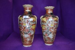A pair of Japanese vase mirrored decoration with scenes or samurai in battle