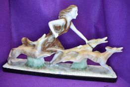 An art deco style figurine of a maiden with hound dogs