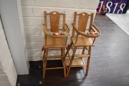 Two child or doll size folding wheeled high chairs in beech wood