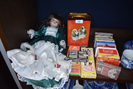 A good quantity of packs of playing cards a vintage tin and a doll.