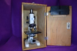 A scientific microscope having wooden carry case
