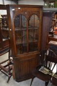 A Priory or Old Charm style corner display with glazed upper section and linen fold cupboard base