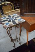 A modern decorative metal plant stand with a tile top