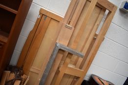 A modern light oak king size bed frame, with drawer storage, disassembled for ease of transport