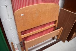 An Edwardian bed and frame having light oak headboards and irons