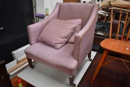 An Edwardian art deco style arm chair on mahogany frame and castors