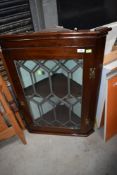 An Edwardian corner cupboard having leaded light glazed door