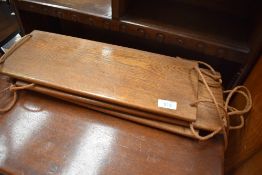 A vintage golden oak hanging display shelf