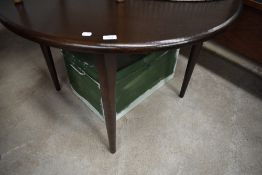 A vintage dark oak circular dining table of simplistic design