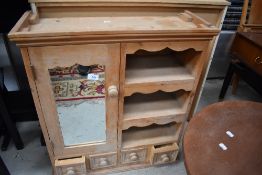 A modern light stripped pine kitchen hallway or bathroom cupboard with mirror door