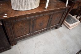 A period oak kist having three carved panels, dimensions approx. W127 D54 H64cm