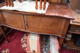 A Victorian side board in a regency style having serpentine front on tapered legs