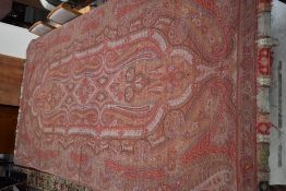 A very large wool Victorian Paisley shawl in reds,blues,browns and greens with fringed edge.some