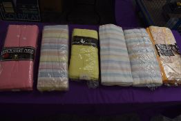 An assortment of vintage and retro bed sheets in original packaging.