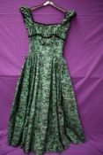 A green Rosecroft model 1950s gown having flocked floral detailing,velvet trim to under bust, sleeve