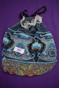 An extensively beaded draw string evening bag having a variety of colourful patterns interwoven with