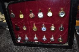 A glazed display case containing eighteen pocket watches or time pieces