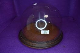 A cheese board or similar cake stand having glass dome top with oak plinth