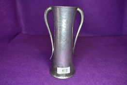 An arts and crafts style Tudric pewter vase having hammered body with double tapered arms 18cm tall
