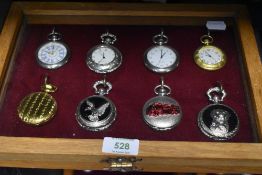 A glazed display case containing eight pocket watches or time pieces