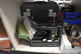 A fine example of a 222k portable sewing machine by Singer with case etc