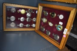 Two glazed display cases containing twenty one pocket watches or time pieces