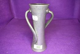 An arts and crafts style Tudric pewter vase having hammered body with double twist arms 17cm tall