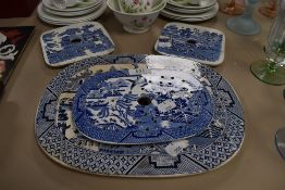 Four antique blue and white ware willow pattern charger and meat drainers large oval having stains