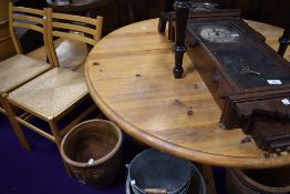 A circular yellow pine dining table on pedestal tripod base
